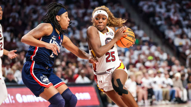 Feb 11, 2024; Columbia, South Carolina, USA; South Carolina Gamecocks guard Raven Johnson (25) drives around UConn Huskies guard KK Arnold (2) in the first half at Colonial Life Arena. 